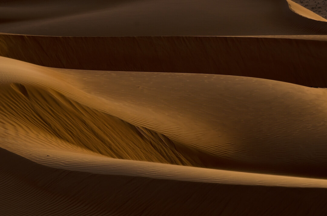 Foto de unas dunas del desierto por la noche, se ven oscuras