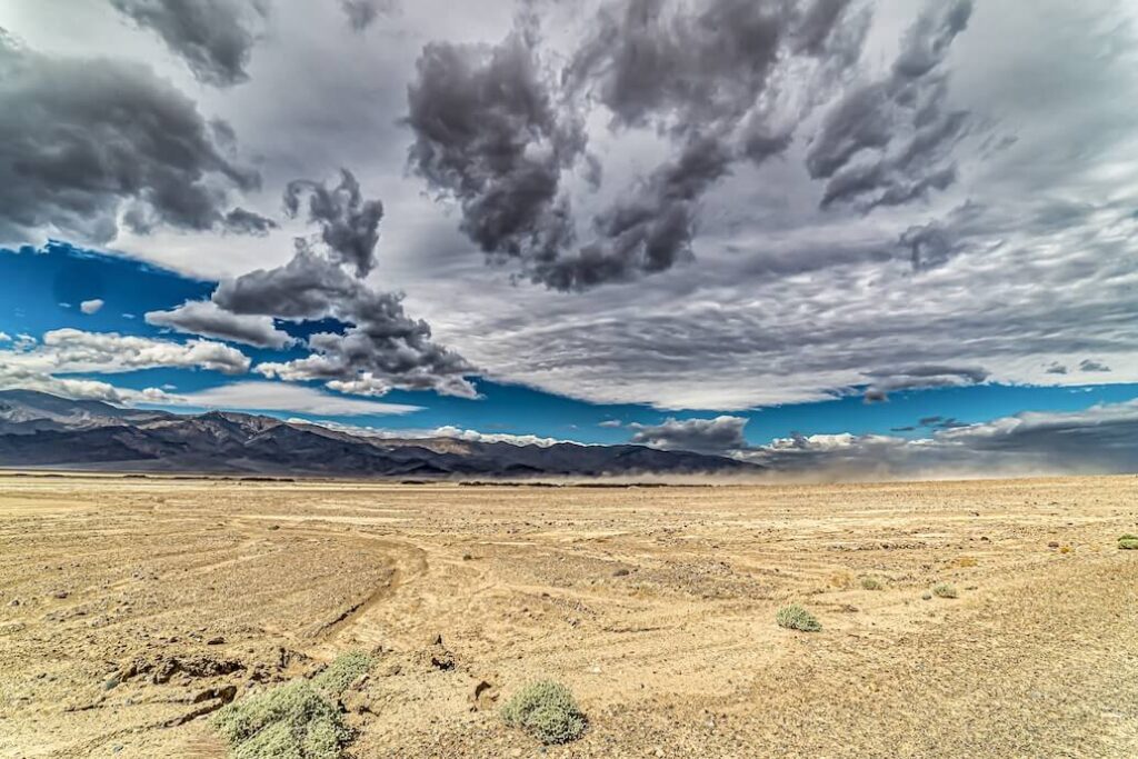 foto de un desierto de arenas claras y cielo con nuebes gris claro y gris oscuro, tormentoso